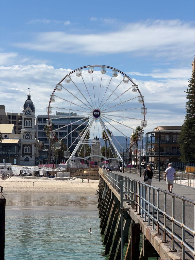 View of the Glenelg Ferris Wheel from the pier, showcasing beachside charm with a clear sky.